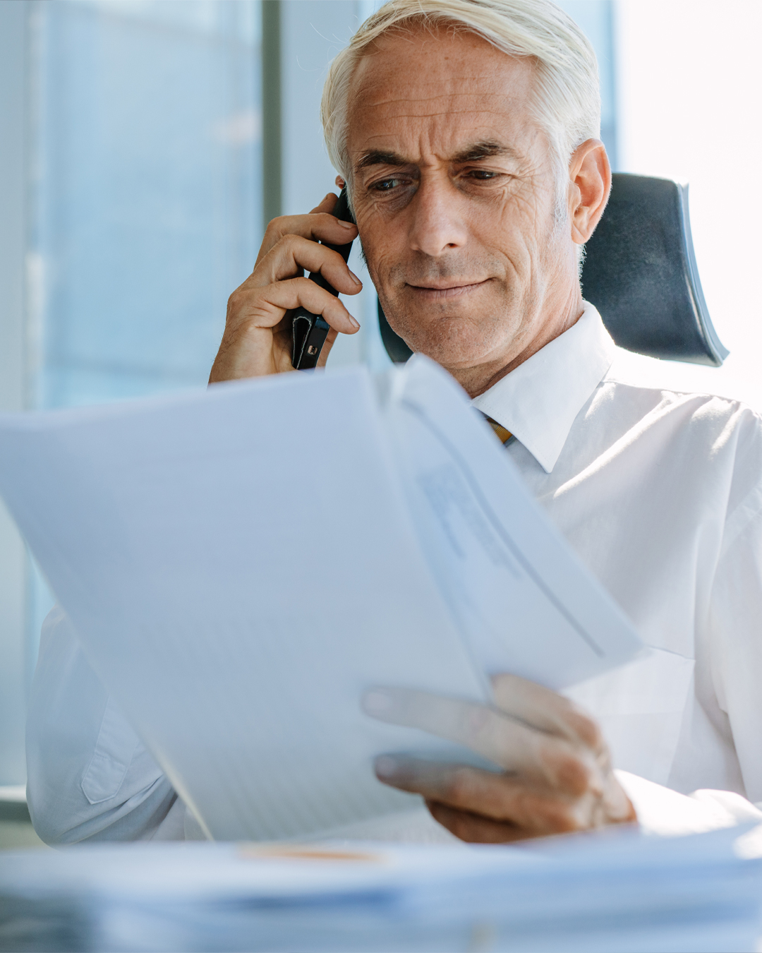 Business man on phone while reading documents