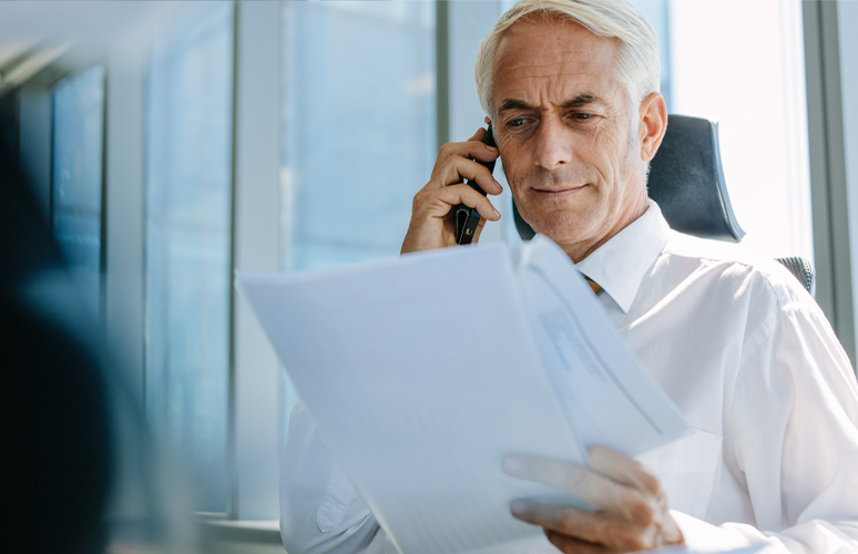 Business man on phone while reading documents