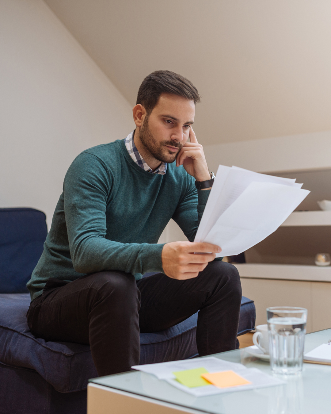 Man looks at papers while sitting