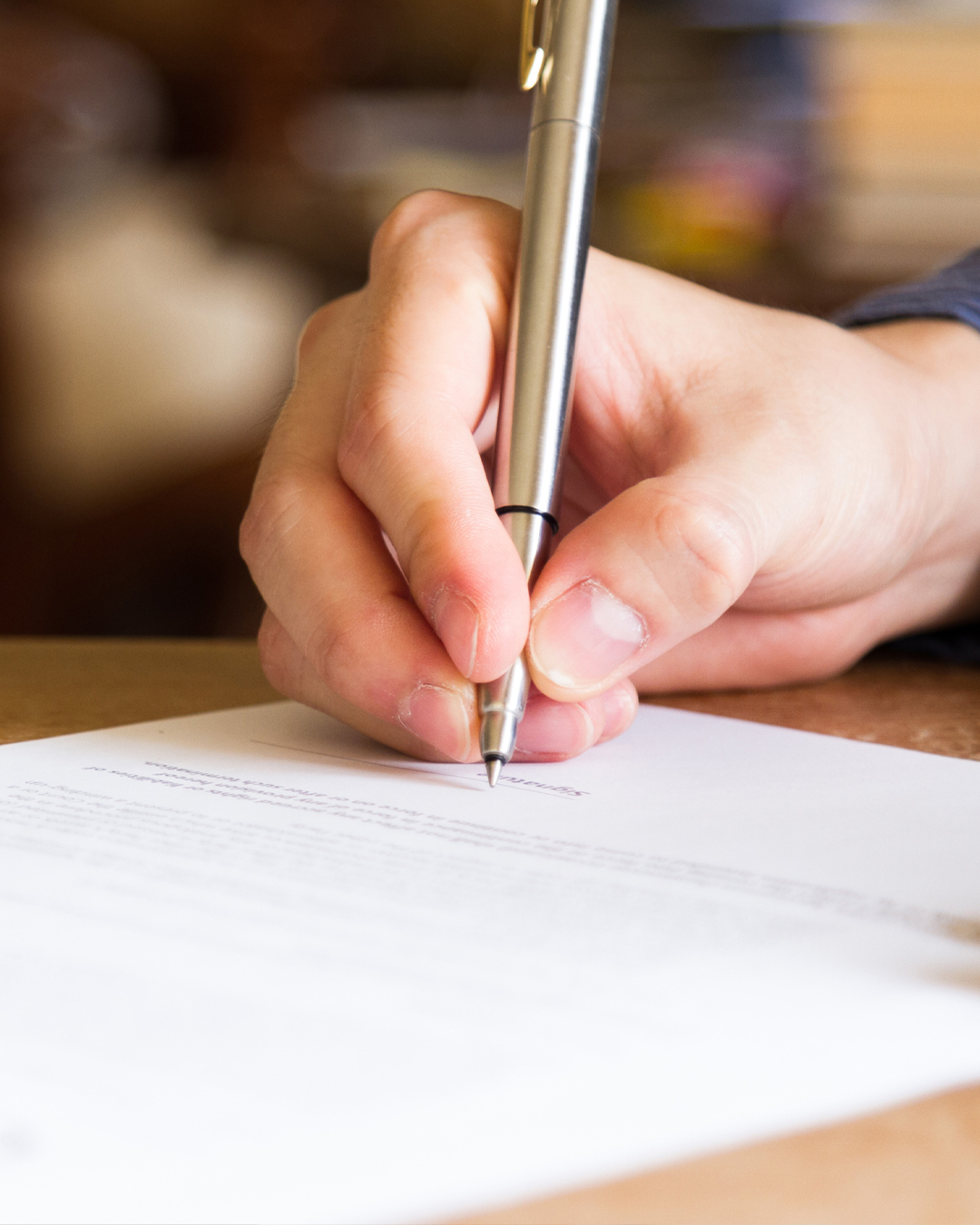 Closeup of person signing a document