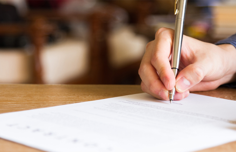 Closeup of person signing a document