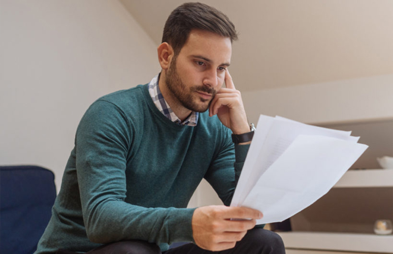 Man looks at papers while sitting