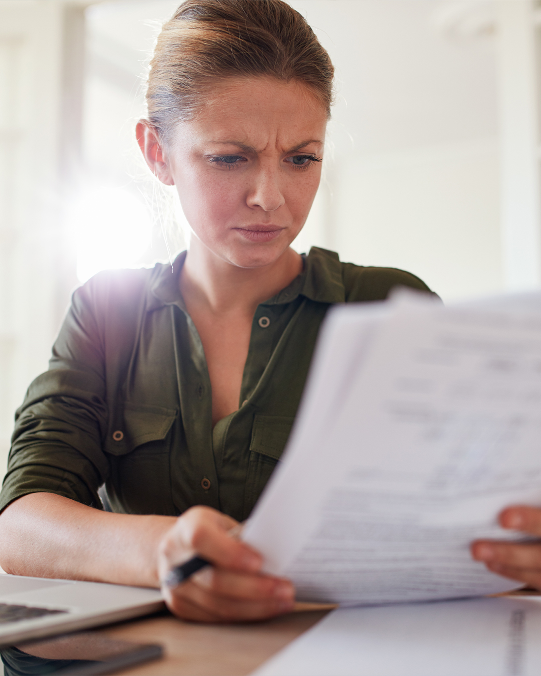 Woman looks at papers with concern