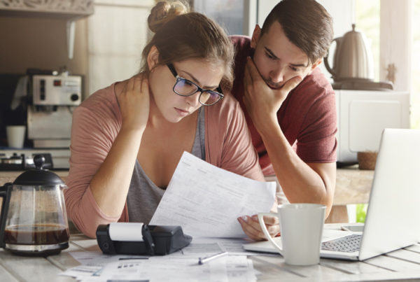 Two people look at paper with concern