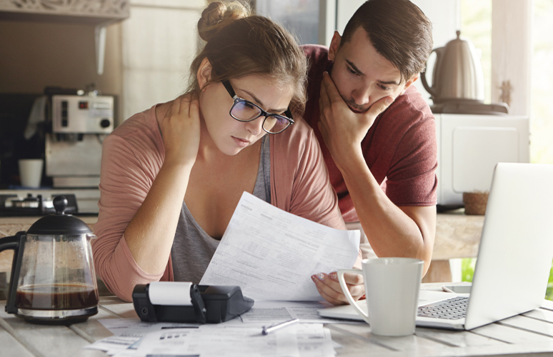 Two people look at paper with concern