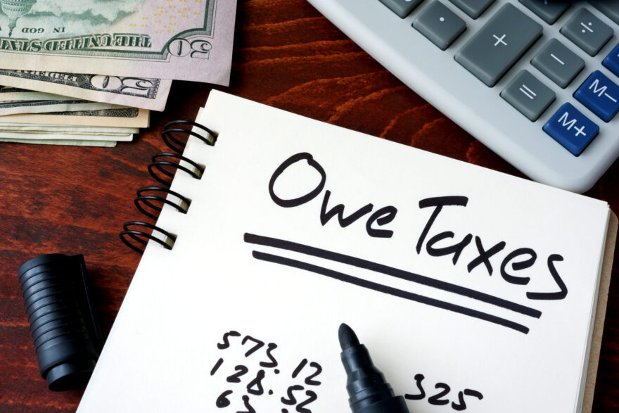 owe taxes written on notepad