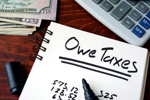 owe taxes written on note pad