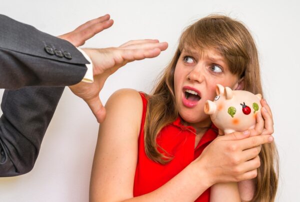 person trying to grab woman's piggy bank
