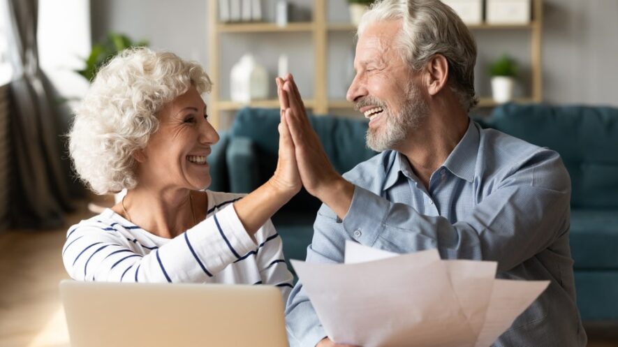 Elderly couple giving high five after completing IRS Form 843
