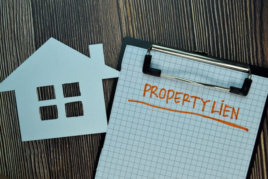 Property lien written on paper and house cutout