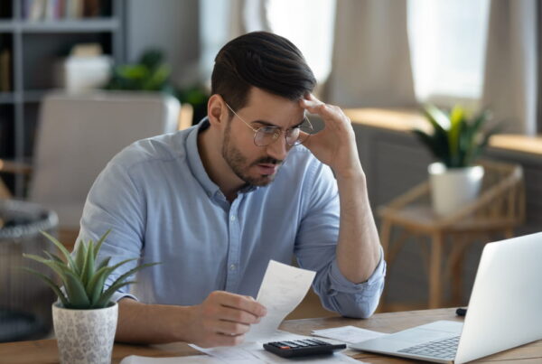 man sitting at desk looking at IRS notice